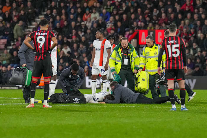 Club medical staff and members of the emergency services pictured treating Tom Lockyer on the field at Bournemouth's Vitality Stadium after the Luton Town captain collapsed during a Premier League game in December 2023